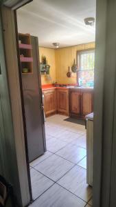 a kitchen with wooden cabinets and a refrigerator at Habitación cómoda, con estacionamiento in Temuco