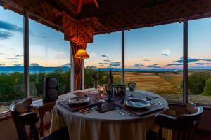 a table in a room with a large window at El Galpón del Glaciar in El Calafate