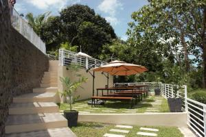 a table with an umbrella and a table with benches at Casita Alyanna in Orani