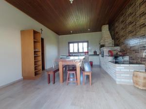 a kitchen with a wooden table and a brick oven at Sítio da Pedra in Cunha +3 photos