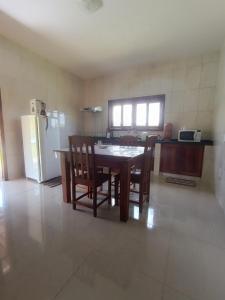 a kitchen with a table and chairs and a refrigerator at Sítio da Pedra in Cunha