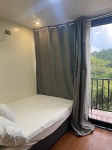 a bedroom with a bed and a window with a balcony at Casita Alyanna in Orani +37 photos