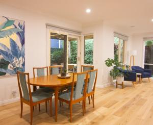 Un comedor con mesa y sillas de madera. en Tranquil Highett House With Storage-2k From Beach!, en Highett