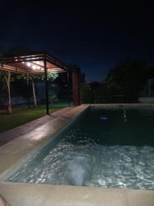 a swimming pool in a backyard at night at Naturaleza y tranquilidad in Zavalla