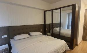 une chambre avec un lit et un grand miroir dans l'établissement Cheapest 3 Bedroom Apartment in Sky House BSD - Duxton 1, à Samporo 32 autres photos