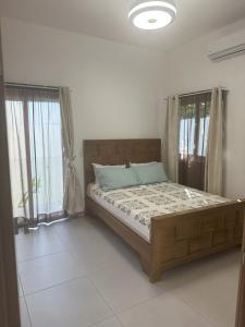 a bedroom with a bed in a room with windows at Luxury Villa Sunny BlueSky Ocean Mtn View in San Felipe de Puerto Plata