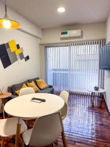 a living room with a table and a couch at DEPARTAMENTO PEATONAL SARMIENTO PLENO CENTRO MENDOZA 3-4 Personas, Con Cochera GRATIS ! in Mendoza