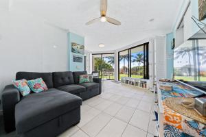 una sala de estar con un sofá y una mesa en Mooloomba Four by Discover Stradbroke, en Point Lookout