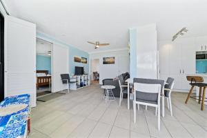 Una sala de estar con mesa y sillas y una cocina. en Mooloomba Four by Discover Stradbroke, en Point Lookout