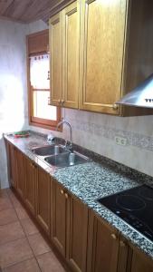 eine Küche mit Holzschränken und einem Waschbecken in der Unterkunft La Perxada de Besolí in Areu