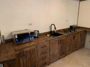 a kitchen counter with a microwave and a sink at Cabaña Rocario Termas de Chillan in Las Trancas +15 photos