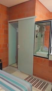 einen Spiegel an einer Wand in einem Zimmer in der Unterkunft "Suites Paraiso Tropical" in São Sebastião + 5 Fotos