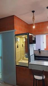 eine Küche mit einer Theke und einem Stuhl in einem Zimmer in der Unterkunft "Suites Paraiso Tropical" in São Sebastião