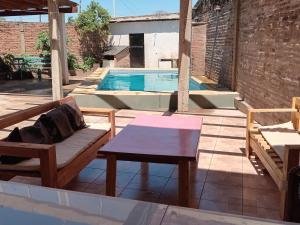 a patio with a bench and a table and a pool at Alojamiento B&B Corrientes in Corrientes
