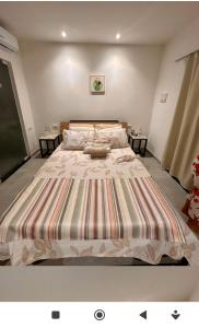 a large bed in a room with two tables at Flats Raízes da Barra in Maragogi