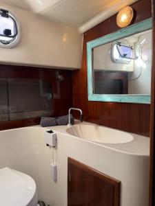a bathroom with a tub and a sink and a toilet at Barco Puerto Calero in Puerto Calero