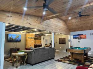 a living room with a couch and a pool table at Brooks bay in Lake Luzerne