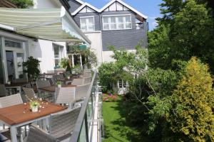 einen Balkon mit Tischen und Stühlen und ein Haus in der Unterkunft Hotel Niggemann in Solingen