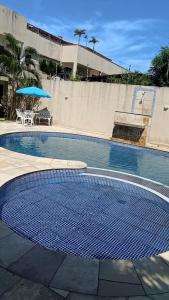 an empty swimming pool with a table and an umbrella at Chalé Sertão e Mar in Canguaretama