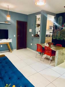 a living room with a table and red chairs at Chalé Sertão e Mar in Canguaretama