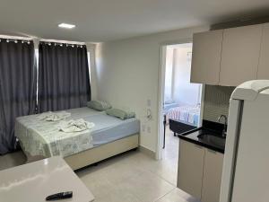 ein kleines Zimmer mit einem Bett und einer Küche in der Unterkunft Apartamento em Porto de Galinhas in Porto De Galinhas + 6 Fotos