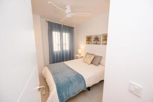 Un dormitorio blanco con una cama y una ventana. en Soho A, en La Herradura