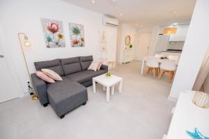 una sala de estar con un sofá y una mesa en Soho A, en La Herradura