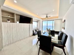 a living room with a dining table and a television at sunset view 1004 in Mazatlán