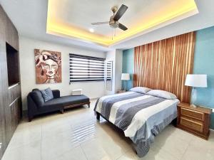 a bedroom with a bed and a couch and a ceiling fan at sunset view 1004 in Mazatlán +35 photos