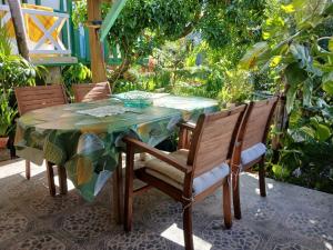 a table and chairs on a patio with plants at Gîte créole, apéro offert, plage à 5min in Vieux-Habitants