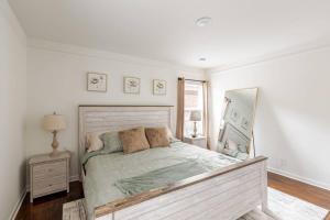 a bedroom with a large bed and a mirror at Cozy 3 Bedroom House Near DFW in Bedford