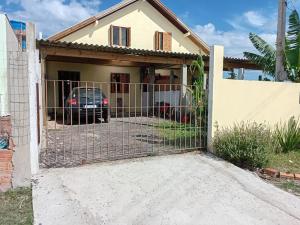 a gate in front of a house at Casa da família Castro in Capão da Canoa +8 photos