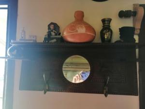 a mirror on a shelf with a woman taking a picture at Cabaña en Cerros Azules in Las Flores