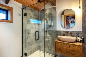 un bagno con lavandino e doccia in vetro di Villa Obsidian including Obsidian Yurts by Waiheke Pure a Waiheke Island Altre 15 foto