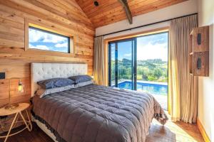 una camera da letto con un letto e una grande finestra di Villa Obsidian including Obsidian Yurts by Waiheke Pure a Waiheke Island