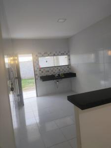 a white kitchen with a sink and a window at Casa para período de carnaval de caicó in Caicó