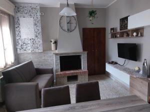a living room with a fireplace and a clock on the wall at La casetta di Rosa - Lentella in Lentella