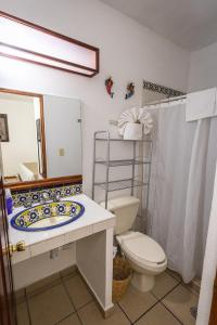 a bathroom with a toilet and a sink and a mirror at Las Mariposas Hotel & Studios in Oaxaca City +68 photos