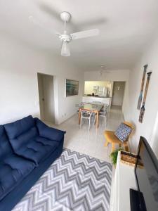 a living room with a blue couch and a table at Ap com varandas e ar condicionados nos quartos in Guarujá
