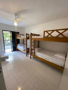a room with two bunk beds and a ceiling fan at Ap com varandas e ar condicionados nos quartos in Guarujá