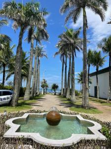 a fountain in a park with palm trees at Ap com varandas e ar condicionados nos quartos in Guarujá +26 photos