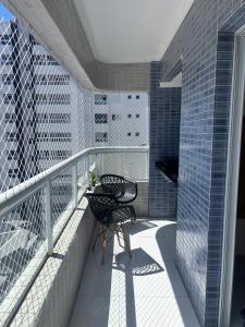 Apartamento Praia Grande caiçara في برايا جراندي: بلكونه عليها طاوله وكرسي