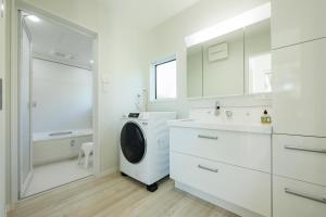 a white bathroom with a washing machine and a sink at 新築2年目Resort & Villa Natural J 城ケ崎海岸と伊豆高原の間 in Ito