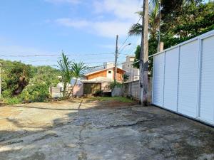 a white fence in front of a house at Temporada Peterle | Casa vista mar Irirí in Anchieta