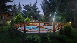 a wooden bridge over a swimming pool in a yard at Cabañas Mijos in El Bolsón