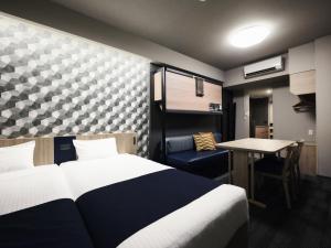 a bedroom with a bed and a table and a desk at MONday Apart Asakusabashi Akihabara in Tokyo