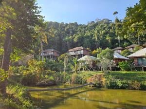 a view of a resort with a pond and trees at Thanya Beach Resort - SHA Plus in Ko Ngai