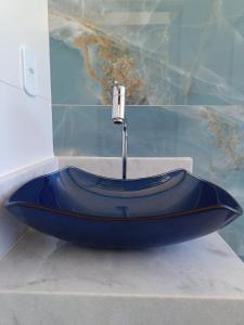 a blue sink in a bathroom with a faucet at Temporada Peterle | Cobertura Irirí in Anchieta +59 photos