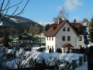 a building in the snow in front of a mountain at Privát Fedoriška in Špindlerův Mlýn