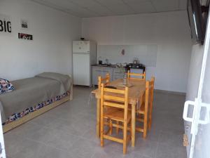 a room with a table and chairs and a bed at Departamentos TUNQUELEN in Colorado River